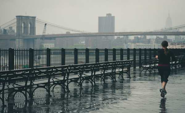 дівчина біжить з Бруклінським мостом на відстані